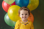 Kleinkind mit Luftballons im Korb